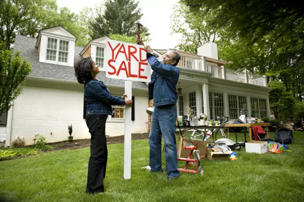 Mature couple putting up sign for Yard Sale